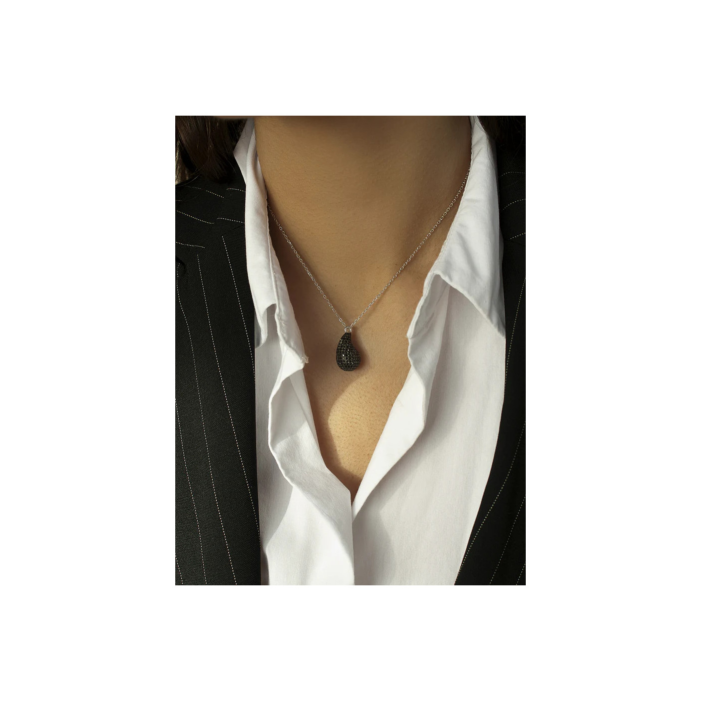 Silver necklace with a black teardrop pendant